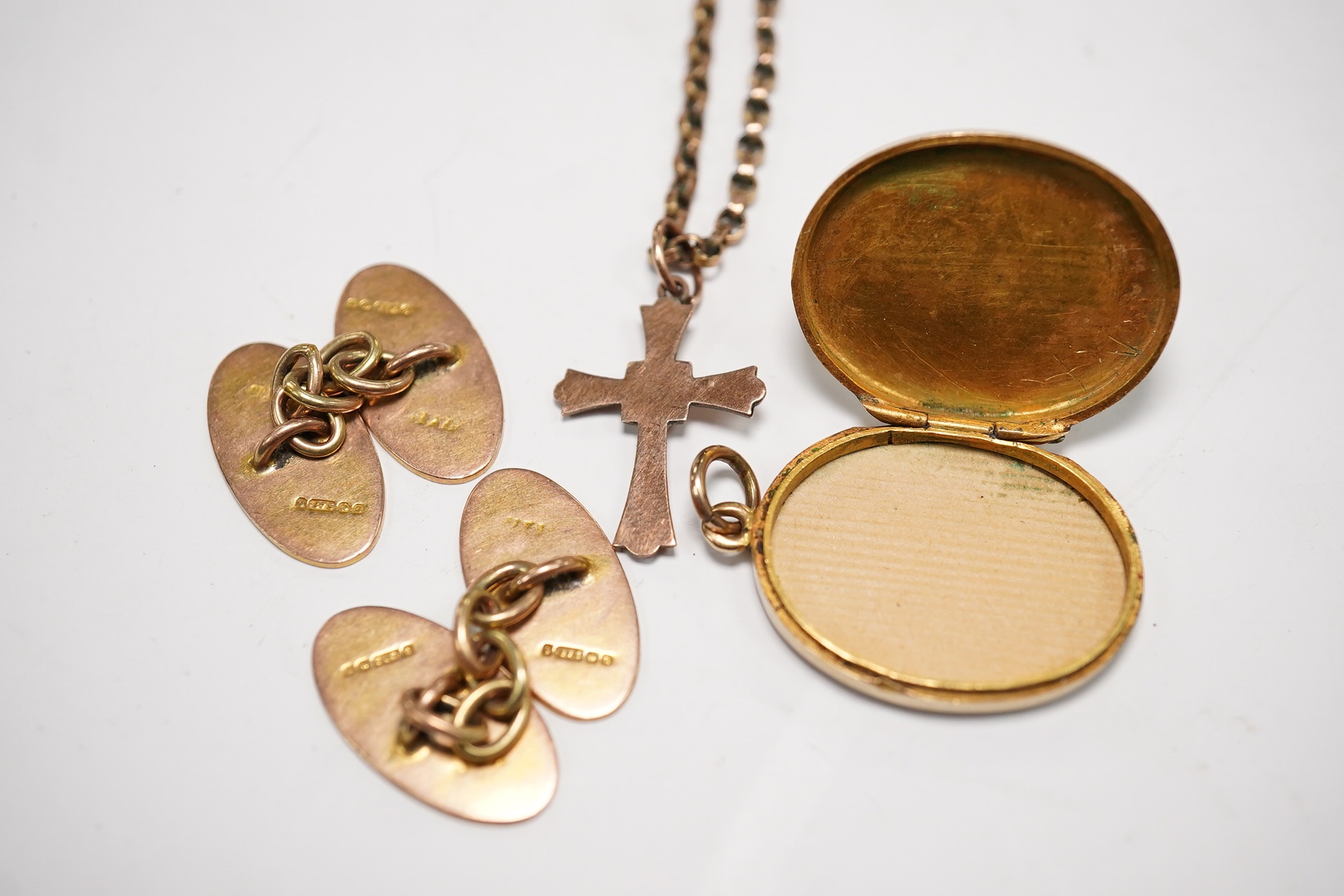 A pair of 9ct gold oval cufflinks, a 9ct chain with 9ct cross pendant and a 9ct gold oval locket, gross weight 14.3 grams. Condition - poor to fair